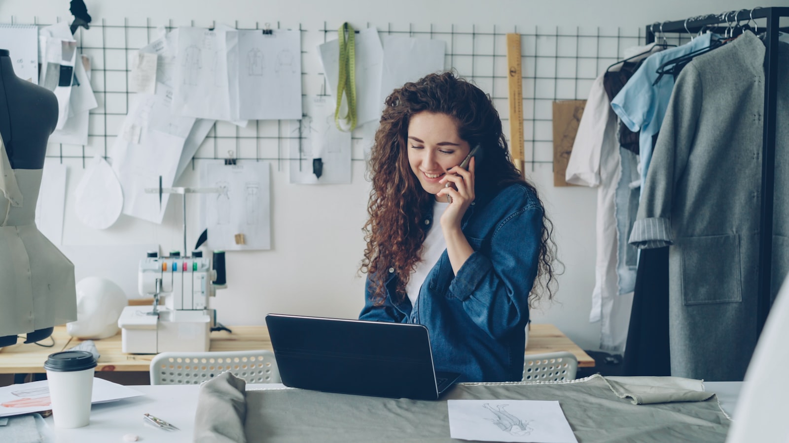 Small business owner working on her laptop and talking on the phone