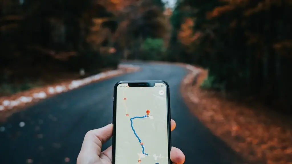 Mano sosteniendo un celular con un mapa de navegación abierto
